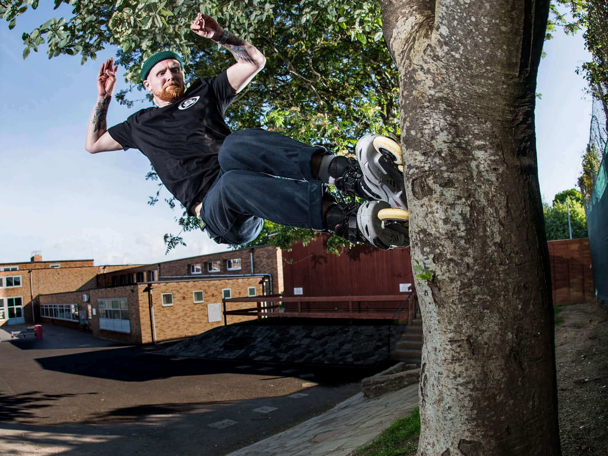 Si Coburn skating Endless Blading in an urban setting with trees and buildings in the background