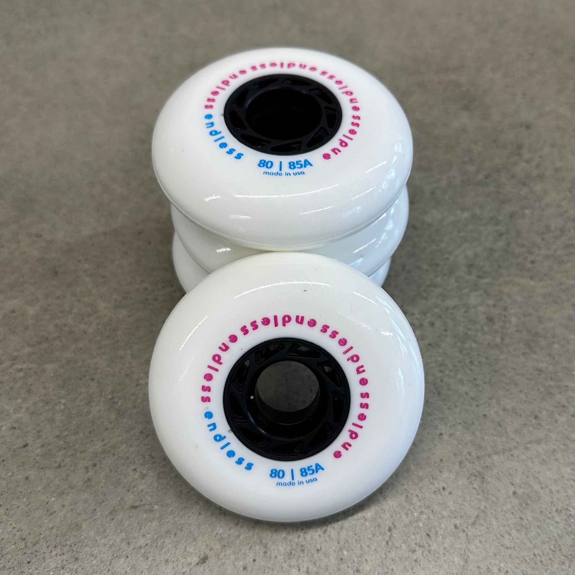 Endless Blading Co. 80 mm white urethane inline skate wheels with black cores and pink and blue branding text