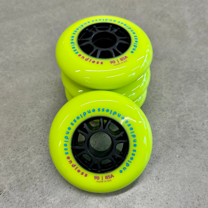 Endless Blading Co. 90mm 85A neon yellow inline skate wheels with black high-performance cores in a stack
