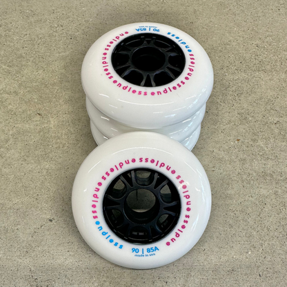 Endless Blading Co. 90mm 85A white inline skate wheels with black cores and pink and blue branding text