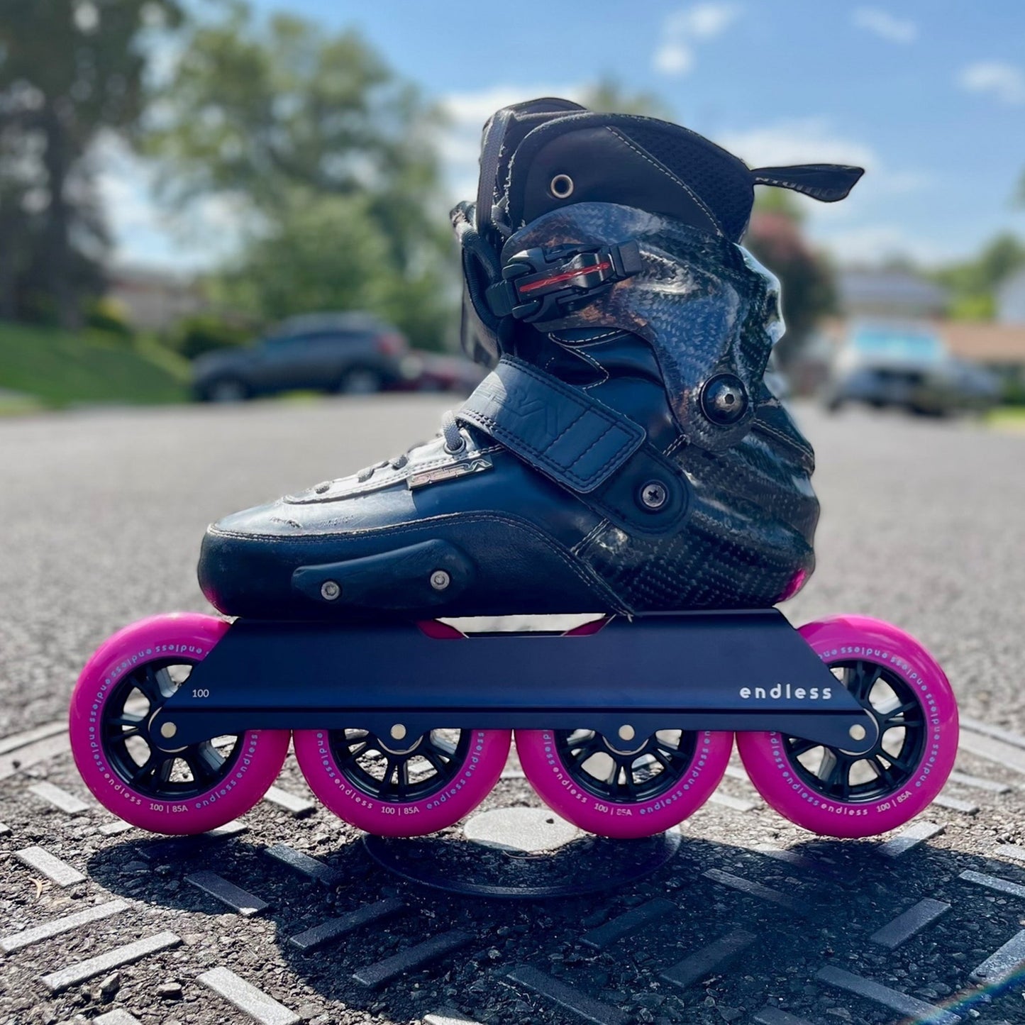 Endless Blading Co. black UFS inline skate frame with four pink 100mm wheels. Features a balanced rocker design.