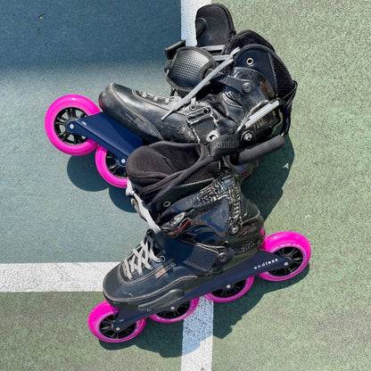 Endless Blading Co. black UFS inline skate frames with four 100mm bright pink wheels.