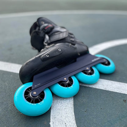 Endless Blading Co. Midnight Blue UFS inline skate frame with four bright turquoise 90mm wheels.