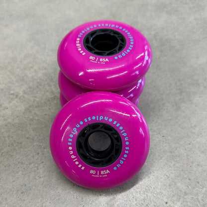 Endless Blading Co. 80 mm neon pink inline skate wheels with black cores and bullet profile for high performance skating.