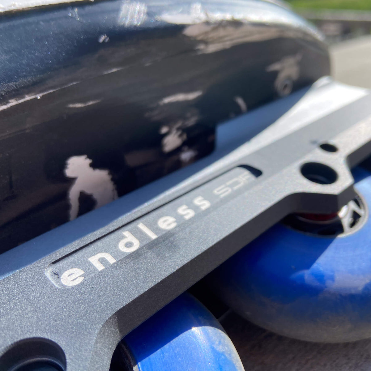 Endless Blading Co. SJR UFS frame in gray aluminum with blue wheels mounted on an aggressive inline skate