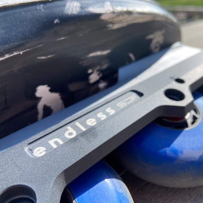 Endless Blading Co. SJR UFS frame in gray aluminum with blue wheels mounted on an aggressive inline skate