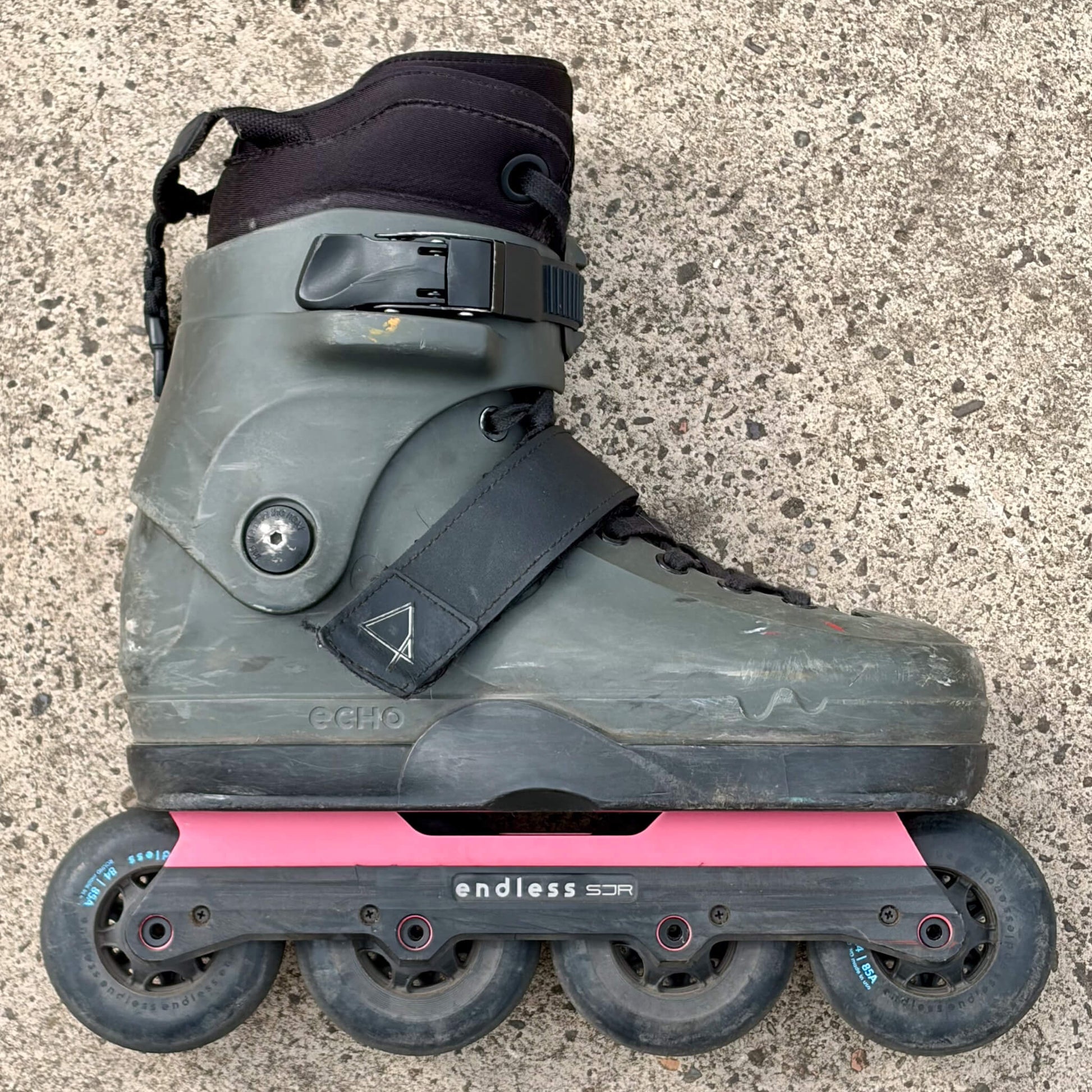 Endless Blading Co. SJR UFS frame in light red mounted on a gray aggressive inline skate boot with four 84mm wheels