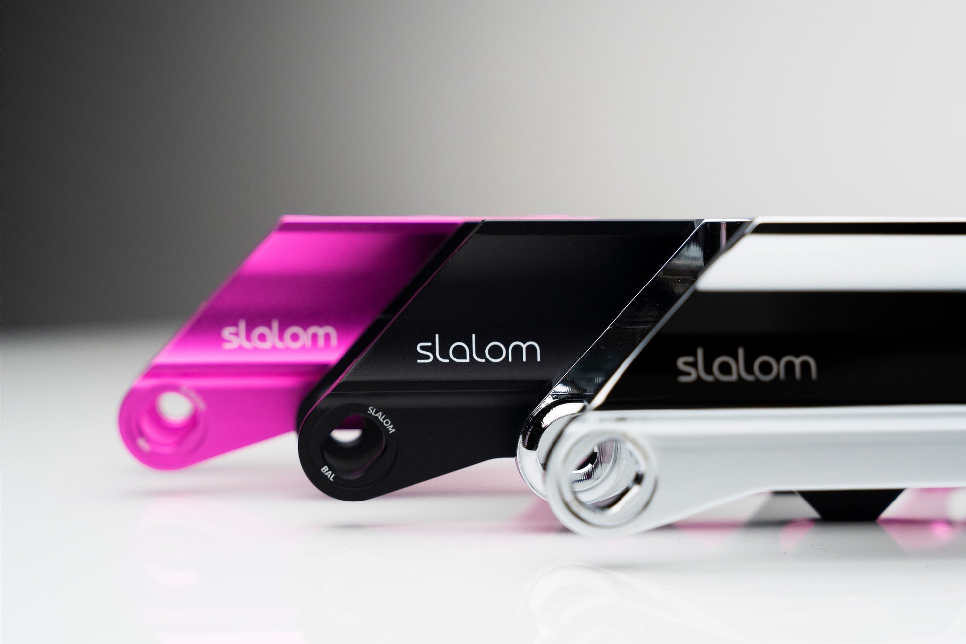 Endless Blading Co. aluminum slalom skate frames in pink, black, and silver with adjustable rocker axles.